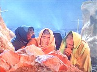 Sulu und das Außenteam wärmen sich an einem Stein.